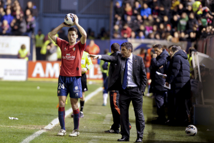 Damiá, jugador osasunista, se dispone a sacar de banda ante la atenta mirada de Mendilibar. (Iñigo URIZ/ARGAZKI PRESS)