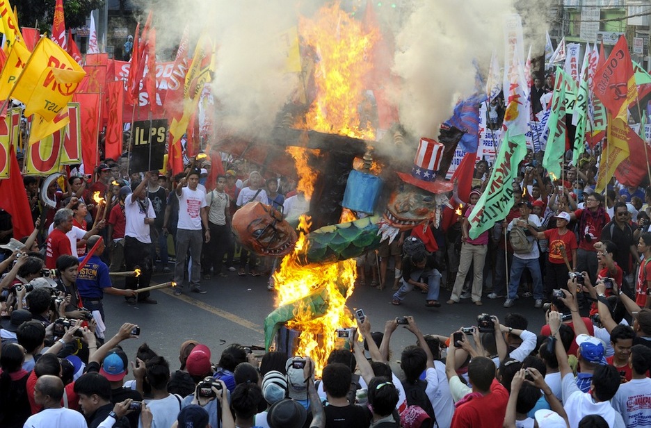 <strong>Filipinak.</strong> Benigno Aquino presidentearen eta ‘Osaba Sam’ pertsonaiaren irudiak erre dituzte Manilan. (AFP) <strong>Filipinak.</strong> Benigno Aquino presidentearen eta ‘Osaba Sam’ pertsonaiaren irudiak erre dituzte Manilan. (AFP)