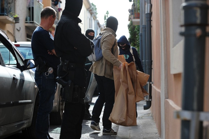 Un policía saca unas bolsas tras el registro de la vivienda de Montpellier. (Sylvain THOMAS/AFP) 