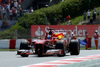 Alonso celebra la victoria con la bandera española. (Lluis GENE / AFP)