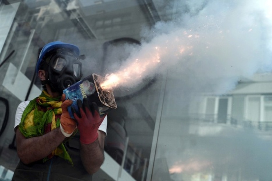 Un manifestante lanza fuegos artificiales en las inmediaciones de la plaza Taksim. (Aris MESSINIS/AFP PHOTO)