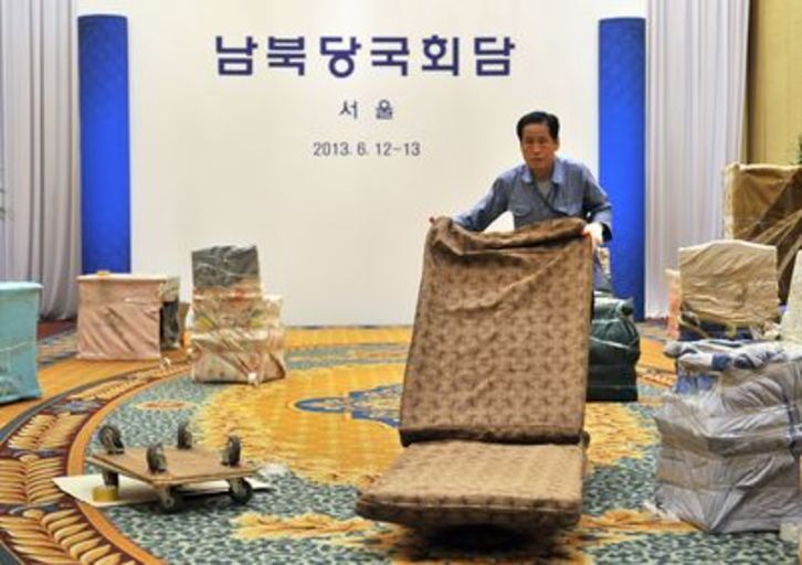 Un operario retira el mobiliario habilitado para el encuentro que finalmente no se ha celebrado. (Jung YEON-JE/AFP PHOTO)