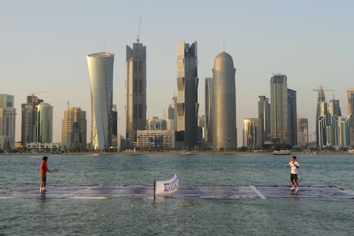 El deporte es la carta de presentación de Qatar. En la imagen, Nadal y Ferrer juegan a tenis en el mar, ante el ‘skyline’ de Doha. (Julien CROSNER/AFP)
