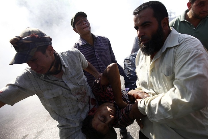 Seguidores de Morsi trasladan a un hombre herido en una manifestación contra el golpe de Estado en El Cairo. (Mahmud KHALED/AFP PHOTO)