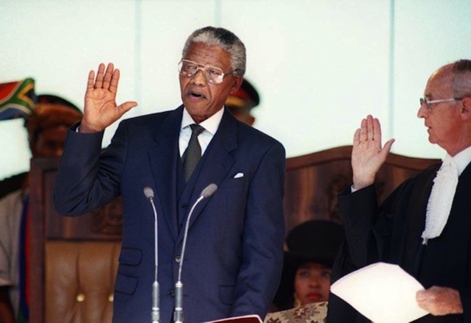El 10 de mayo de 1994 toma el cargo como el primer presidente negro de Sudáfrica y pone en marcha una política de reconciliación nacional con De Klerk como vicepresidente. (AFP PHOTO)