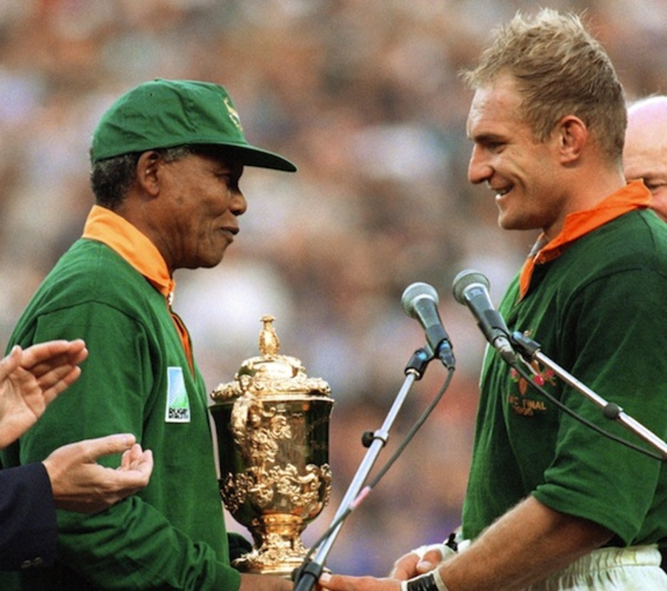 En junio de 1995, felicita al capitán del equipo nacional de rugby, François Pienaar, por haber ganado el campeonato mundial. Este deporte fue una importante herramienta para la reconciliación. (AFP PHOTO)
