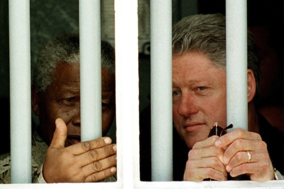 Visita en 1998 junto al presidente estadounidense Bill Clinton la celda de Robben Island donde Mandela estuvo encarcelado. EEUU no le retirará hasta 1998 de su lista de «terroristas». (AFP PHOTO) 