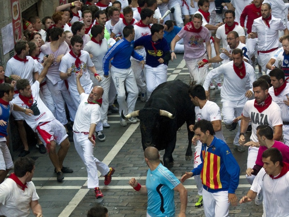 Un mozo intenta esquivar a uno de los toros a su paso por Estafeta. (Juan Carlos RUIZ/ARGAZKI PRESS)