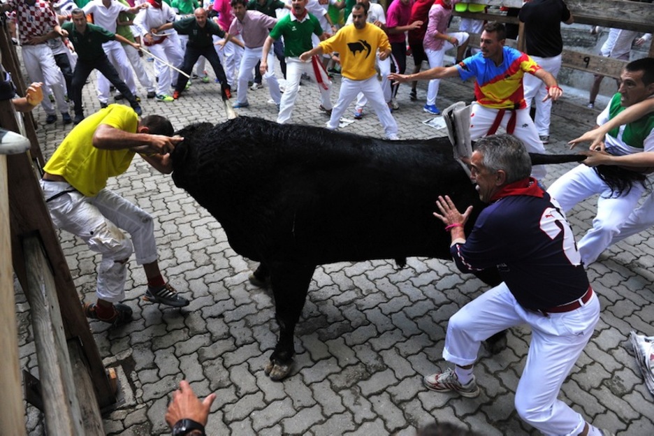 El toro que se ha quedado rezagado ha embestido contra este mozo en el callejón. (Idoia ZABALETA/ARGAZKI PRESS)