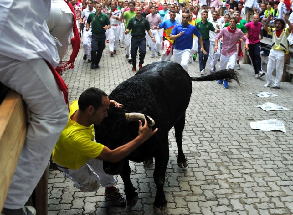 Momento en el que el toro rezagado pilla a un mozo en el callejón. (Idoia ZABALETA/ARGAZKI PRESS)