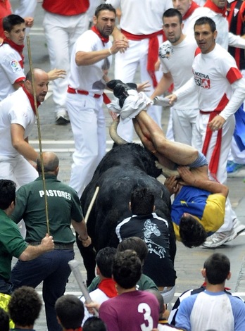 El toro descolgado arremete contra un mozo en el tramo de Telefónica. (Idoia ZABALETA/ARGAZKI PRESS)