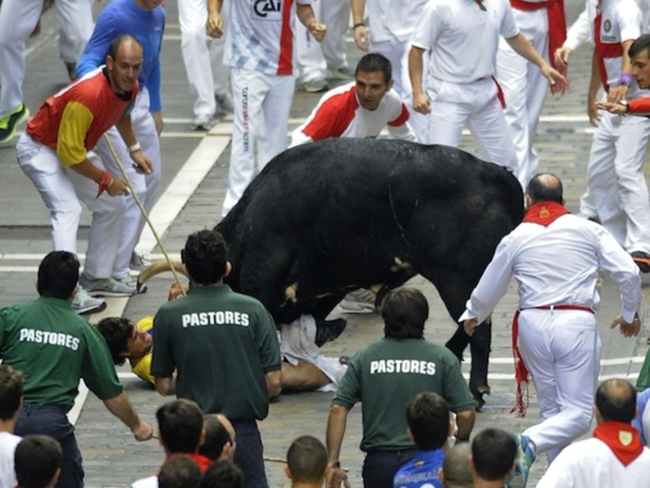 A pesar de los esfuerzos del resto de mozos y de los pastores, el toro se ha obcecado con el corredor. (Ander GILLENEA/AFP PHOTO)