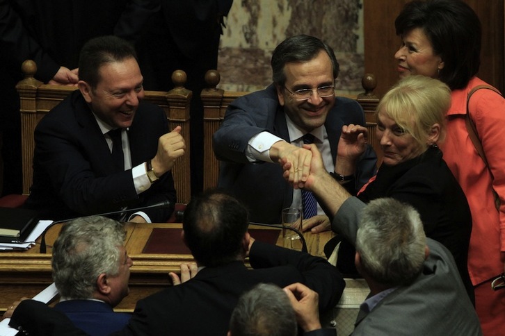 El ministro de Finanzas, Yannis Stournaras, y el primer ministro, Antonis Samaras, se felicitan tras la votación. (AFP)