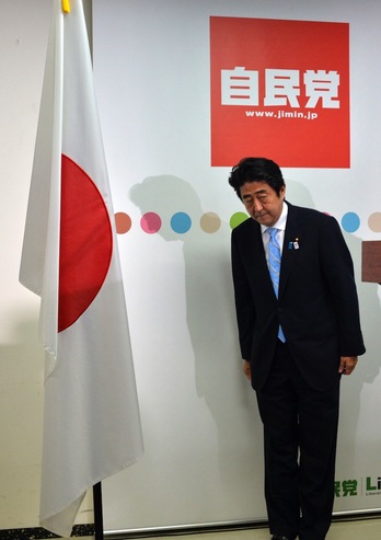 El primer ministro japonés, Shinzo Abe, saluda a la bandera antes de comparecer ante los medios. (Yoshikazu TSUNO/AFP)
