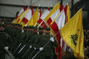 Soldados de Hizbullah desfilan con la bandera libanesa y con la de su organización. (Ramzi HAIDAR/AFP)