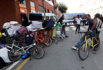 Los desalojados, en la calle con sus pertenencias tras la operación policial. (Quique GARCÍA/AFP)