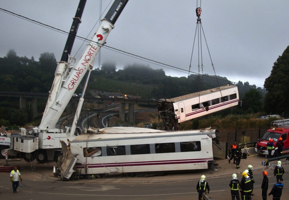 Una grúa eleva uno de los vagones accidentados. (AFP) Una grúa eleva uno de los vagones accidentados. (AFP)