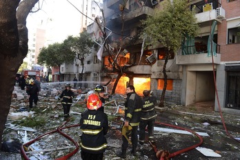 Los bomberos realizan labores de extinción en la zona afectada por la explosión. (Sebastian GRANATA/AFP)