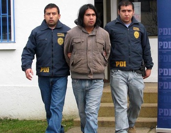 El joven mapuche Rodrigo Melinao, trasladado por dos policías en una de sus detenciones. (NAIZ.INFO)