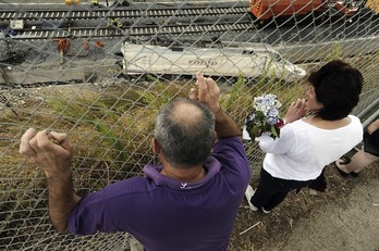 Dos personas observan los restos del tren siniestrado (Rafa RIVAS / AFP PHOTO)