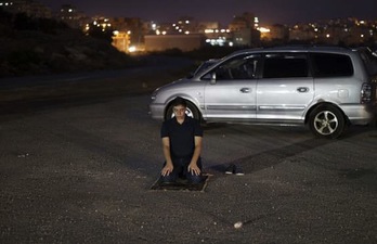 Un palestino reza al anochecer mientras aguarda la liberación de los presos (Ahmad GHARABLI / AFP PHOTO)