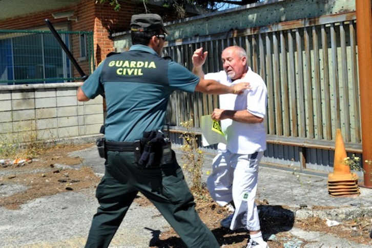 Un guardia civil esgrime su porra ante un extrabajador de Inasa (Idoia ZABALETA / ARGAZKI PRESS)
