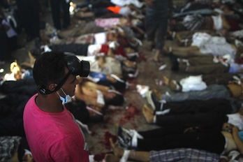 Un hombre mira a los cadáveres apilados en la plaza Rabaa Al-Adawiya. (Moshaab EL-SHAMY/AFP PHOTO)