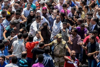 Varios islamistas abren un pasillo para que un grupo de mujeres pueda abandonar la mezquita Al-Fath de El Cairo, el pasado sábado. (AFP PHOTO)