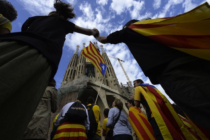 Manos entrelazadas frente a la Sagrada Familia de Barcelona. (Lluis GENE/AFP)