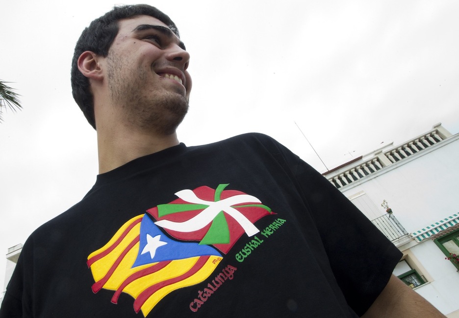 Un joven con la estelada y la ikurriña en su camiseta. (Jose JORDAN/AFP)