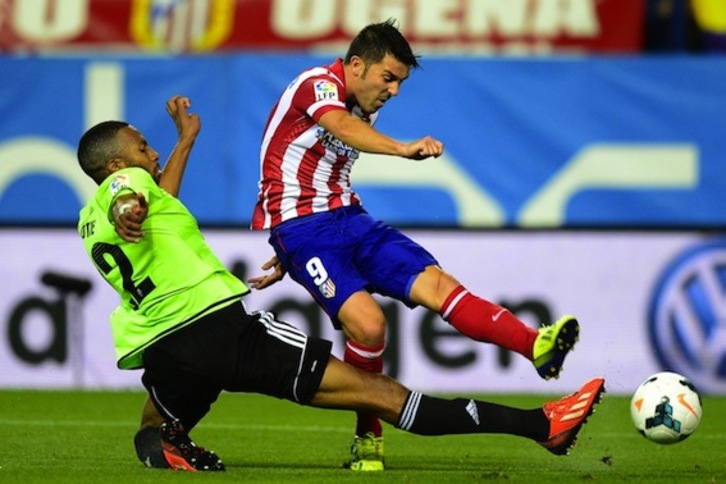 David Villa trata de lanzar ante Loties. (Javier SORIANO/AFP PHOTO)