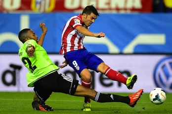 David Villa trata de lanzar ante Loties. (Javier SORIANO/AFP PHOTO)