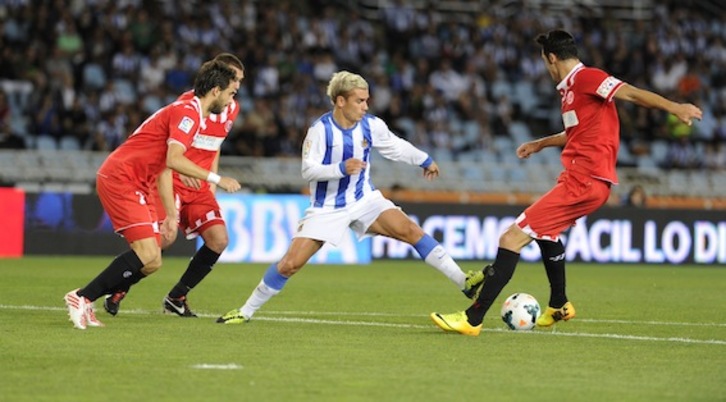 Griezmann, Sevillako jokalariz inguratuta. (Jon URBE/ARGAZKI PRESS)