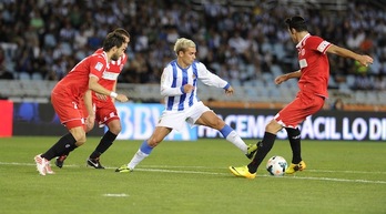 Griezmann, Sevillako jokalariz inguratuta. (Jon URBE/ARGAZKI PRESS)