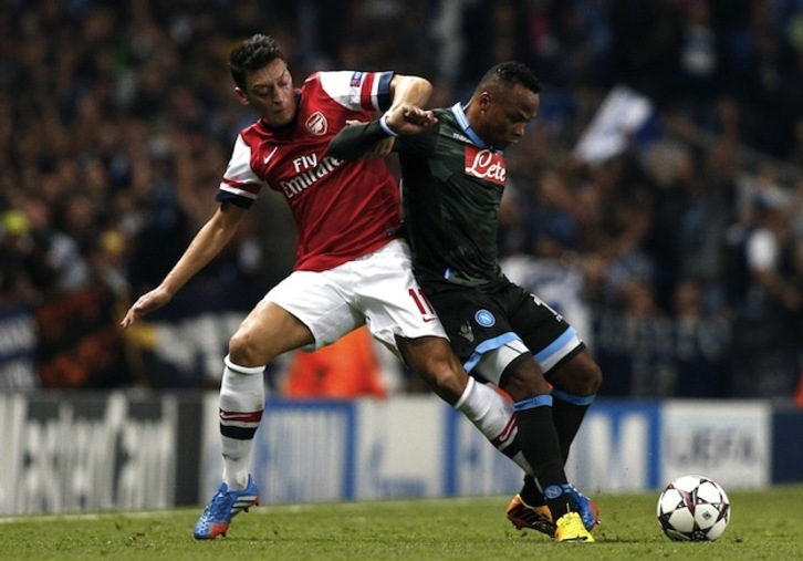 Ozil (Arsenal) pugna con Zuñiga (Nápoles). (Adrian DENNIS / AFP PHOTO)