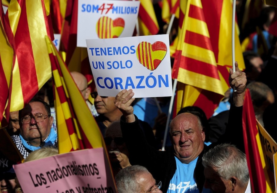 «Bihotz bakarra dugu’ dioen kartela, manifestari baten eskuetan. (Josep LAGO/AFP)
