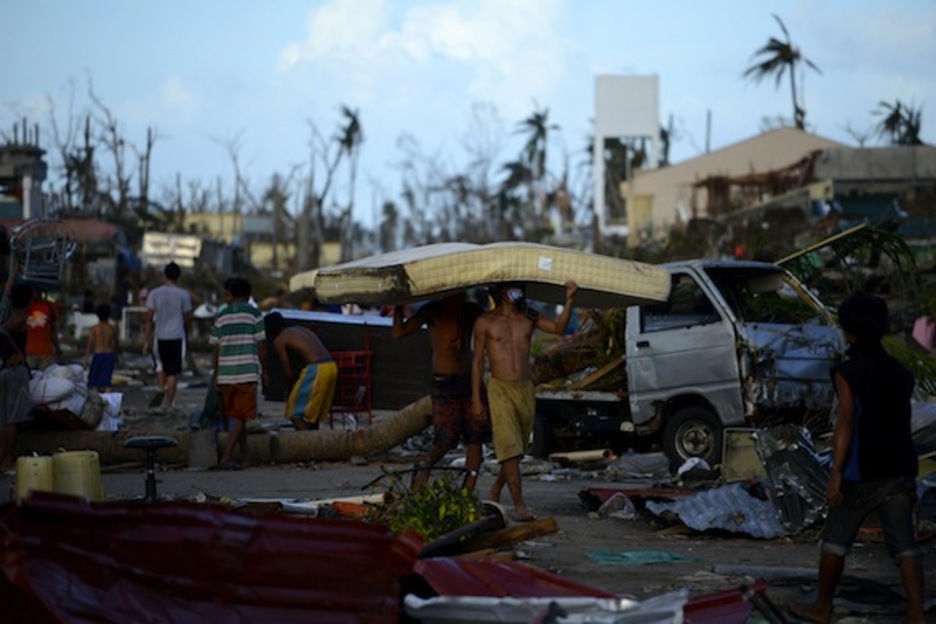 Dos personas trasladan un colchón por las calles de Palo, en la asolada isla de Leyte. (Noel CELIS/AFP PHOTO)