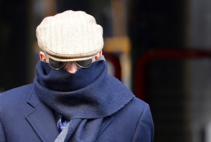 González Pacheco, alias ‘Billy el Niño’, sale de la AN ocultando su rostro. (Gerard JULIEN/AFP)