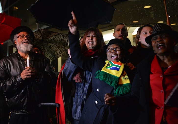 Un grupo de personas canta y baila en una velada por Mandela ante el Consulado de Sudáfrica en Nueva York. (Stan HONDA/AFP)