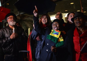 Un grupo de personas canta y baila en una velada por Mandela ante el Consulado de Sudáfrica en Nueva York. (Stan HONDA/AFP) 
