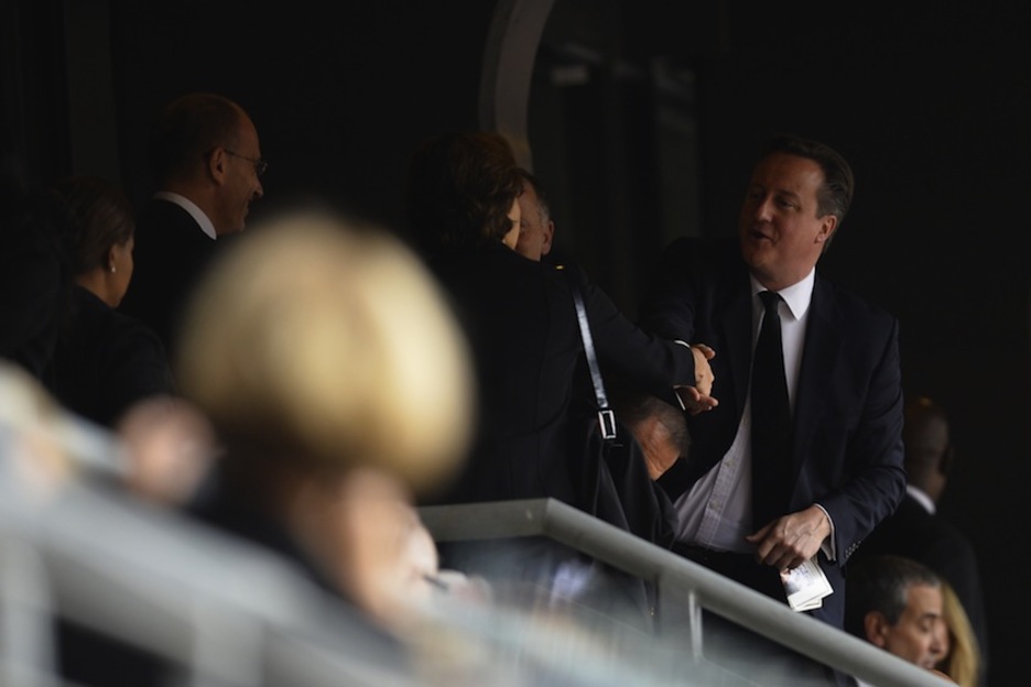 El primer ministro británico, David Cameron, saluda a otros asistentes en el estadio. (Odd ANDERSEN/AFP)