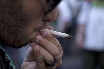 Un hombre fuma marihuana durante una marcha a favor de su libre consumo. (Pablo PORCIUNCULA/AFP)