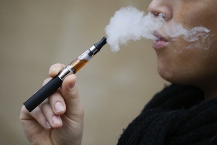 Una mujer fuma un cigarrillo electrónico. (Kenzo TRIBOUILLARD/AFP PHOTO)