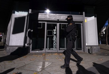 Un policía camina ante la sede del PP en Madrid. (Dani POZO/AFP)