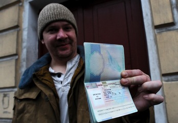 El británico Anthony Perrett muestra su visado de salida. (Olga MALTSEVA/AFP)