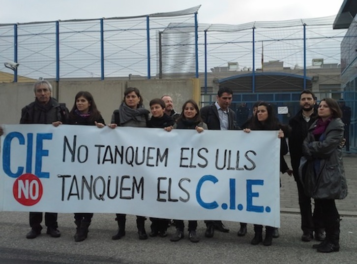 Diputados del Parlament, junto a miembros de ‘Tanquem els CIEs’, ante el centro de la Zona Franca. (NAIZ.INFO)