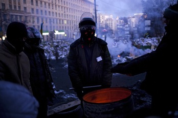 Manifestantes antigubernamentales tratan de entrar en calor, esta mañana en Kiev. (Angelos TZORTZINIS / AFP PHOTO)