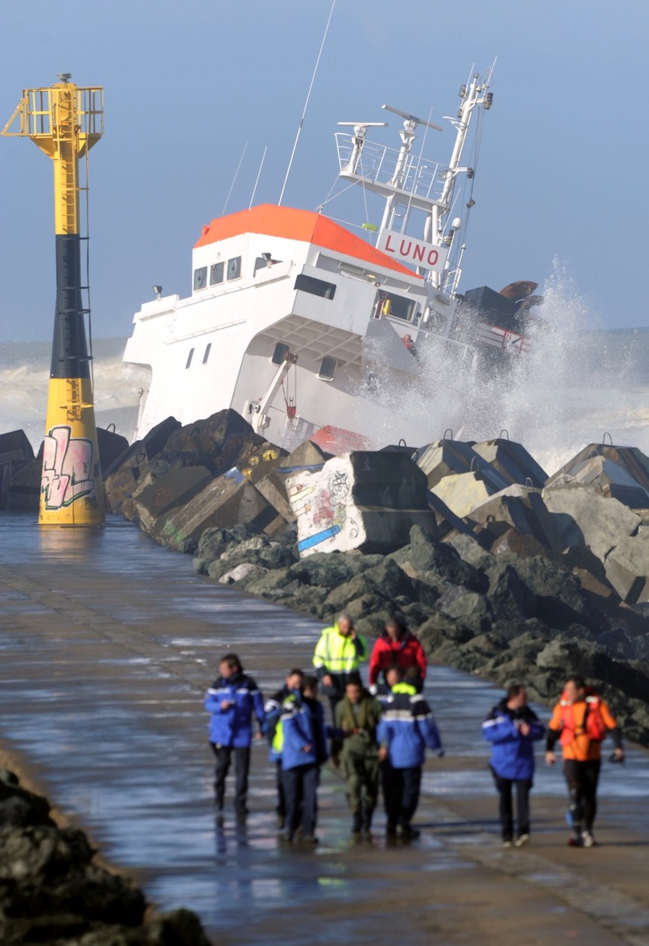 El fuerte oleaje ha dificultado las labores de salvamento pero finalmente los 12 tripulantes han sido rescatados. (Gaizka IROZ/AFP)