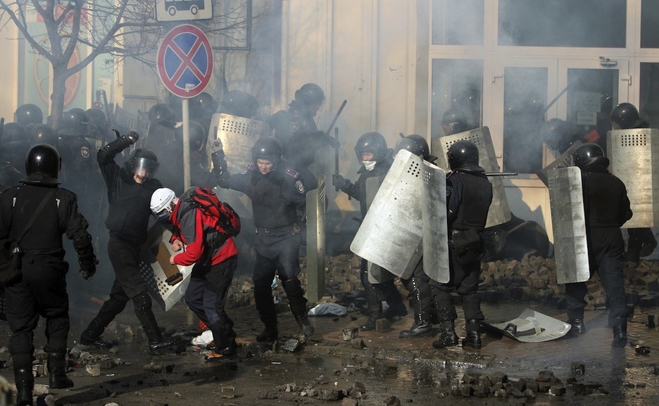Dos policías se disponen a golpear a un manifestante. (Anatolii BOIKO /AFP PHOTO)
