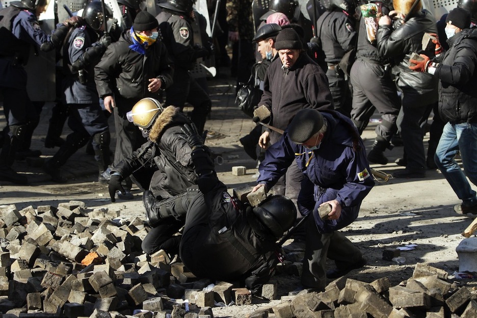 Un policía es atacado tras caer al suelo. (Anatolii BOIKO /AFP PHOTO)